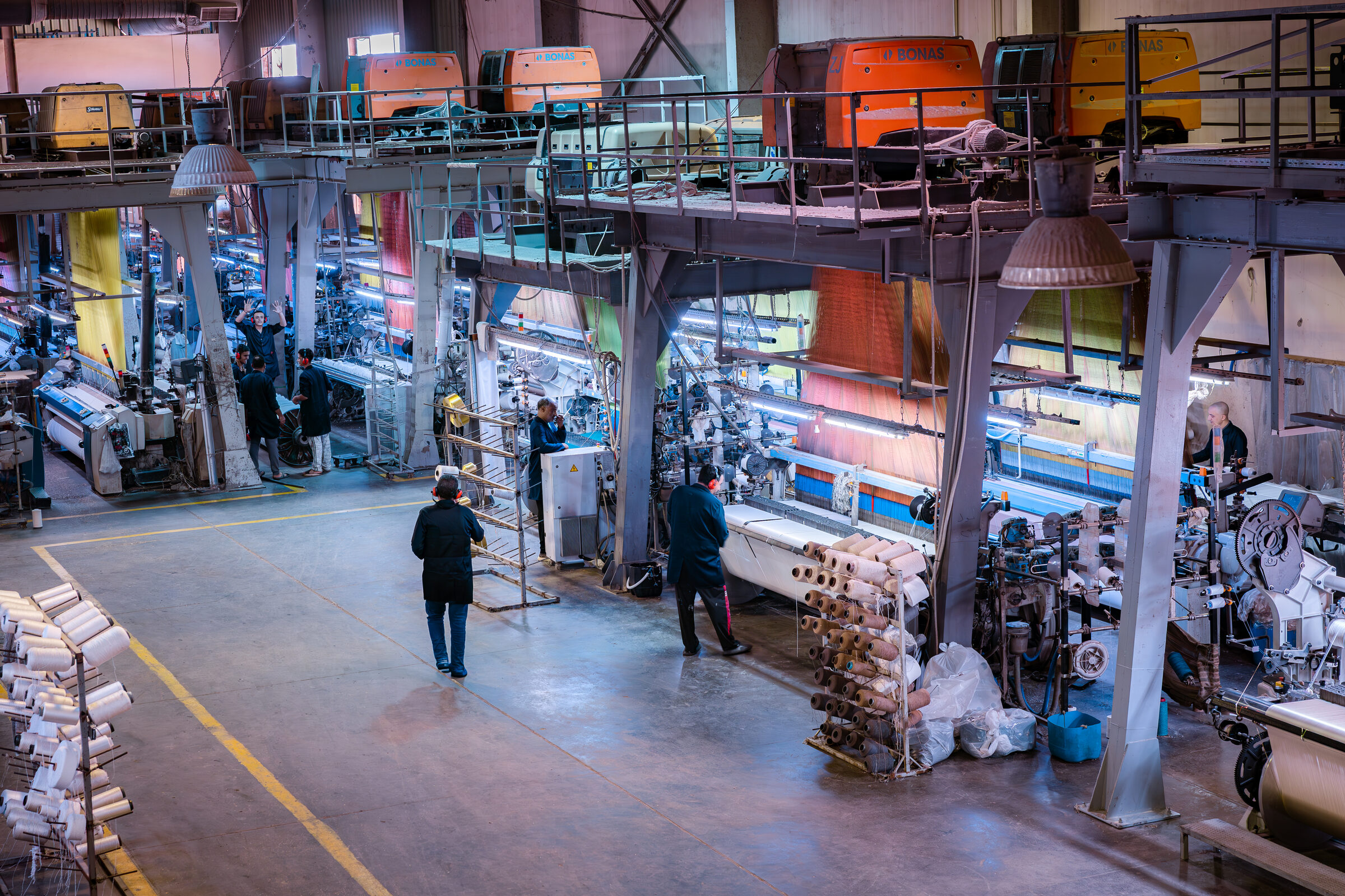 Jacquard looms and weavers on the factory floor at Kozman